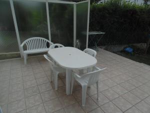 una mesa blanca y 2 sillas en el patio en Appartement entièrement rénové avec Wifi tout à pied, en Royan