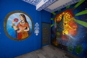 una habitación con espejo y una pintura en la pared en Mandala bagpackers, en Jaipur