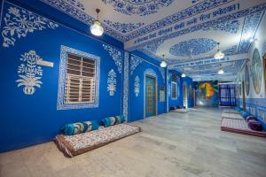 Habitación con paredes azules y techos pintados de azul y blanco. en Mandala bagpackers, en Jaipur