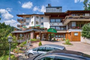 a large building with cars parked in front of it at Ringhotel Mönch`s Waldhotel in Unterreichenbach