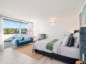 a bedroom with a bed and a chair and a window at XQ Collection La Casa De Frida - Modern Studio with Balcony in Sydney