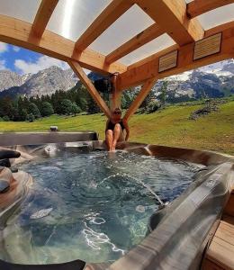 un hombre sentado en un jacuzzi en un jacuzzi en Chalet-Hôtel Inarpa, en La Clusaz