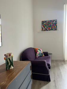 uma sala de estar com um sofá roxo e uma mesa em Colosseo Living Suites em Roma