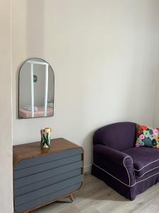 uma sala de estar com um sofá roxo e um espelho em Colosseo Living Suites em Roma