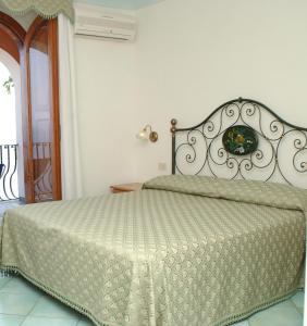 ein Bett in einem Schlafzimmer mit einer weißen Wand in der Unterkunft Hotel Il Gabbiano in Positano