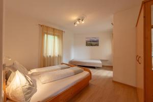 a bedroom with two beds and a window at Weinhof am See in Caldaro