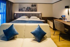 Una habitación de hotel con una cama con almohadas azules. en Ostend Hotel, en Ostende