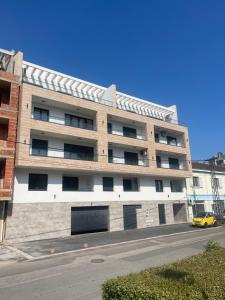 un edificio de apartamentos con un coche amarillo aparcado delante de él en Lux Tea Pancevo, en Pančevo