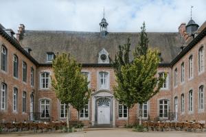 stary ceglany budynek z drzewami przed nim w obiekcie Château de Looz w mieście Borgloon