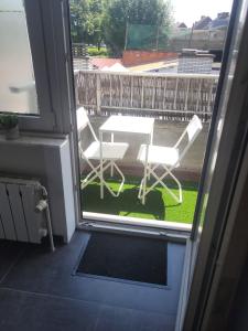 un patio con tavolo e sedie sul balcone. di Espace Cuesmois chambre a Mons