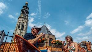 a man and woman sitting in a chair in front of a church at B&B De zilveren reiger in Middelburg