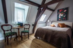 a bedroom with a bed and a table and chairs at B&B De zilveren reiger in Middelburg