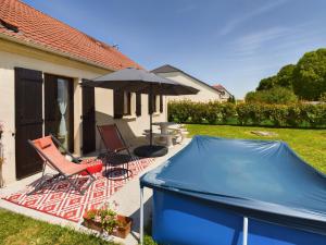 un patio con 2 sillas, una sombrilla y una piscina en Maison du Bien-Être, en Romilly-sur-Seine