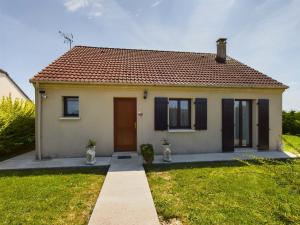 una pequeña casa amarilla con un patio de césped en Maison du Bien-Être, en Romilly-sur-Seine