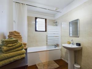 y baño con lavabo, bañera y una pila de toallas. en Maison du Bien-Être, en Romilly-sur-Seine