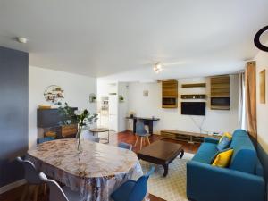 sala de estar con sofá azul y mesa en Maison du Bien-Être, en Romilly-sur-Seine