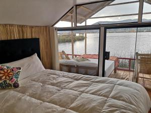 A bed or beds in a room at Uros Suma Qhota Lodge