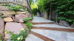 a stone path with stairs and flowers next to a fence at Villa Dolomiti in Ortisei