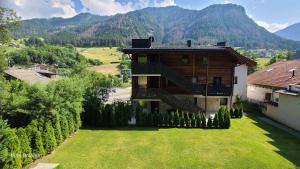 a house in the middle of a yard with a mountain at Villa Dolomiti in Ortisei