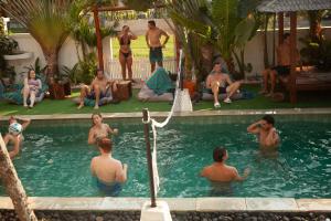 un gruppo di uomini seduti in piscina di Nyaman Hostel a Canggu