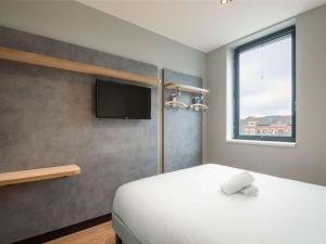 - une chambre avec un lit et une télévision à écran plat dans l'établissement ibis budget Leuven Centrum, à Louvain