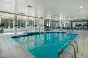 uma grande piscina com água azul num edifício em Hilton Garden Inn Detroit Metro Airport em Romulus