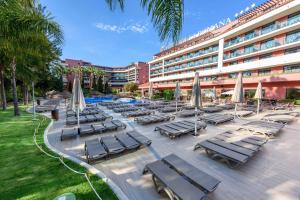 - un groupe de chaises longues et de parasols devant l'hôtel dans l'établissement Ohtels Vil·la Romana, à Salou