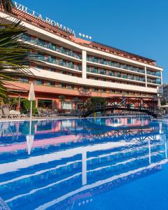 un hôtel avec une piscine en face d'un bâtiment dans l'établissement Ohtels Vil·la Romana, à Salou