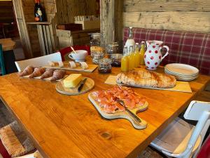 ein Holztisch mit Brot und Essen darauf in der Unterkunft Orso Bianco Hotel & Chalet in Sauze dʼOulx