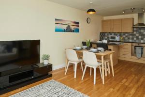 een keuken met een tafel en stoelen bij Stylish 2-Bedroom Apartment with Free Parking in Halifax