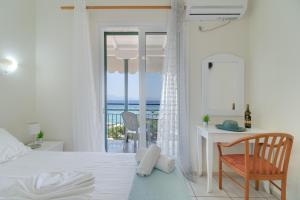 una camera con letto e scrivania con vista sull'oceano di S7 apartment a Nikiana