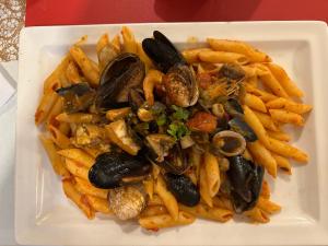 un plato blanco de comida con mejillones y papas fritas en Horus Hôtel, en Fréjus