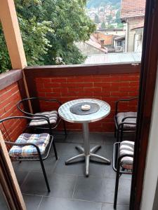 a patio with a table and chairs on a balcony at Apartment and rooms"Tabašnice"Tuzla centar in Tuzla