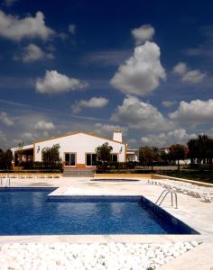 una piscina frente a un edificio en Vila Gale Alentejo Vineyard - Clube de Campo, en Albernoa