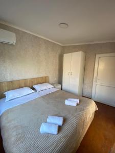 a bedroom with a bed with two towels on it at Hotel Doko in Martvili