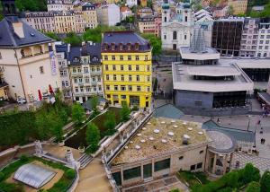 ein gelbes Gebäude mitten in einer Stadt in der Unterkunft Hotel Ester in Karlsbad