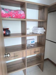 un armario con estanterías de madera en una habitación en Cómodo, nuevo y con linda vista., en Manizales