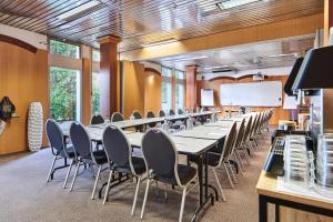 een vergaderzaal met tafels en stoelen en een whiteboard bij Hôtel Charlemagne by Happyculture in Lyon