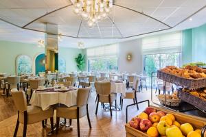 een eetkamer met tafels en stoelen en fruit. bij Hôtel Charlemagne by Happyculture in Lyon