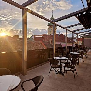 ein Restaurant mit Tischen und Stühlen auf einem Balkon in der Unterkunft sgrafit hotel - Self Check-In in Retz