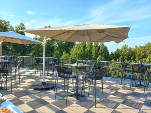 un patio avec des tables, des chaises et des parasols dans l'établissement Dali Hôtel Perpignan - Restaurant, à Perpignan