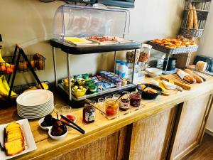 um buffet com muita comida na mesa em Hotel Douglas em Puteaux