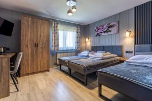 a hotel room with two beds and a television at U Haliny in Biały Dunajec