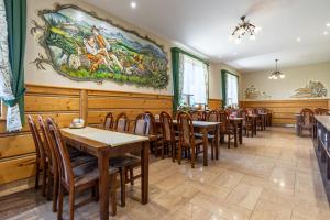 a dining room with tables and chairs and a painting on the wall at U Haliny in Biały Dunajec