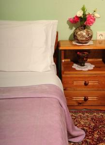 a bedroom with a bed and a table with a vase of flowers at Chrysoula's Guests in Ioannina