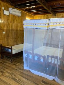 a bedroom with a canopy bed and a bench in it at Malayalam Lake Resort in Alleppey