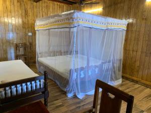 a bedroom with a canopy bed in a cabin at Malayalam Lake Resort in Alleppey