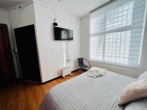 um quarto com uma cama e uma televisão de ecrã plano em Nomada 870 Hotel Work em Osorno