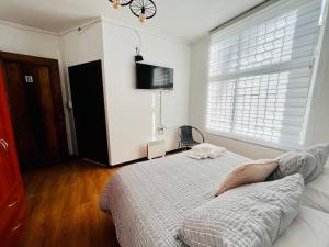 um quarto com uma cama, uma televisão e uma janela em Nomada 870 Hotel Work em Osorno