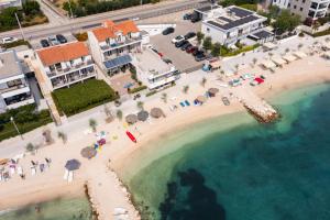 una vista aerea di una spiaggia con ombrelloni e persone di Seaside Luxury Suites a Podstrana